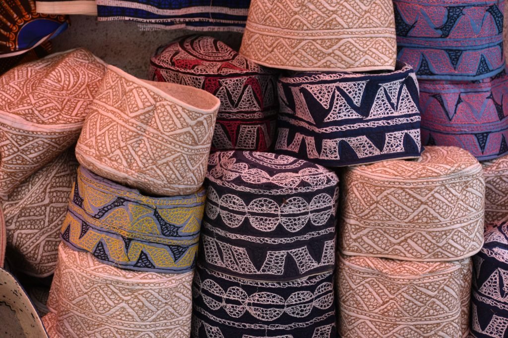 Stack of embroidered traditional Swahili kofia caps at a Stone Town market, Zanzibar.